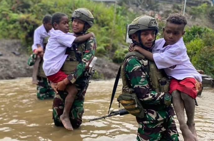 Satgas TNI Bantu Anak-Anak Kampung Dal Seberangi Sungai saat Berangkat Ke Sekolah